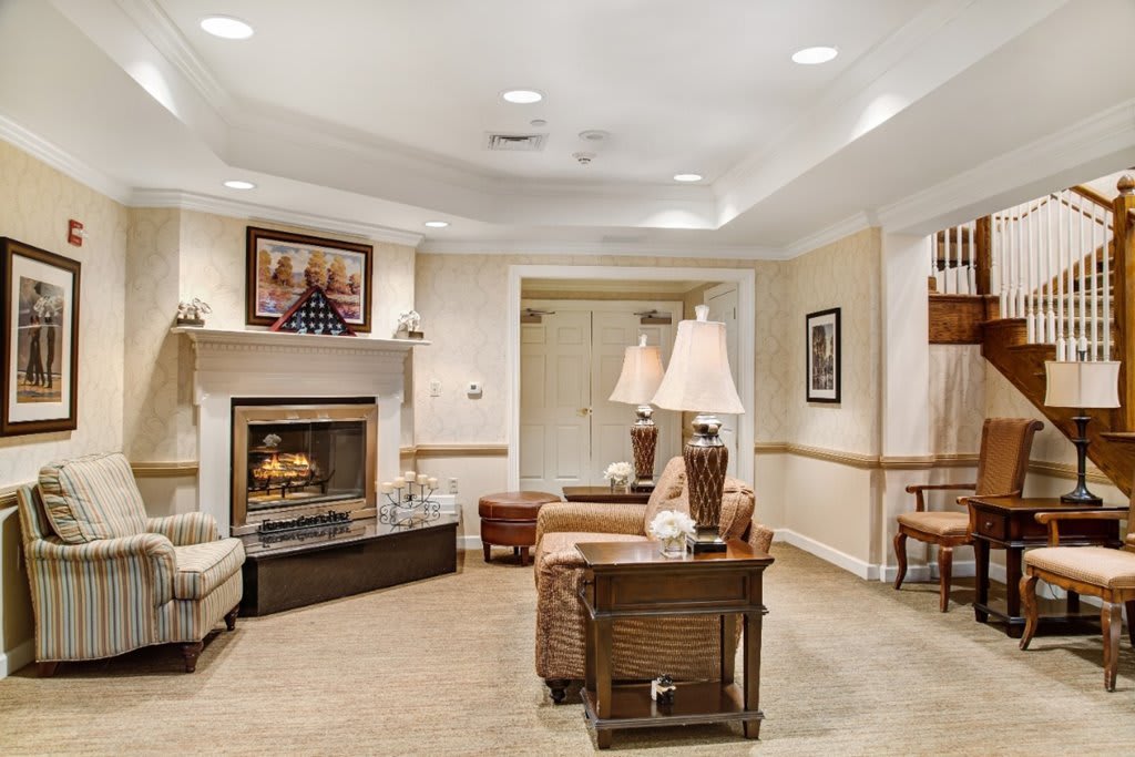 A cozy living room featuring a fireplace, sofas, a coffee table, and elegant lighting.