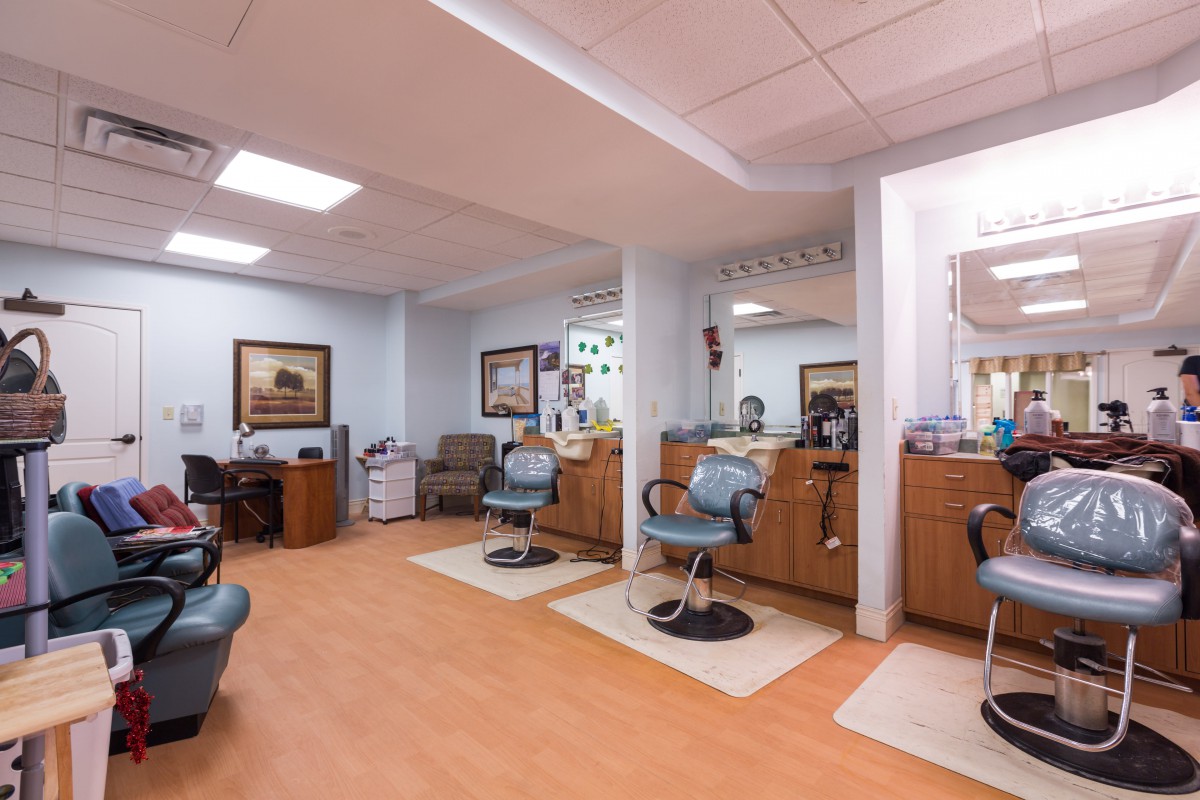 A well-organized barber shop interior featuring multiple styling stations with chairs and mirrors.