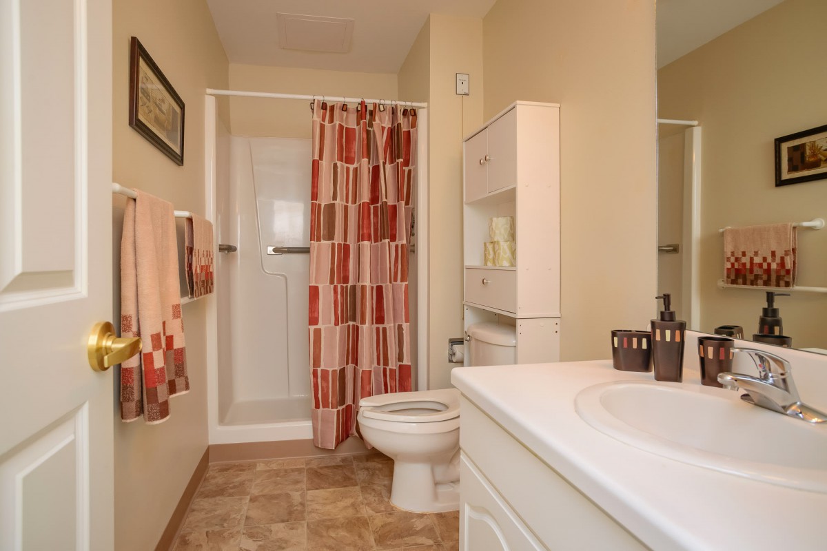 A neatly organized bathroom with a shower, toilet, and sink.