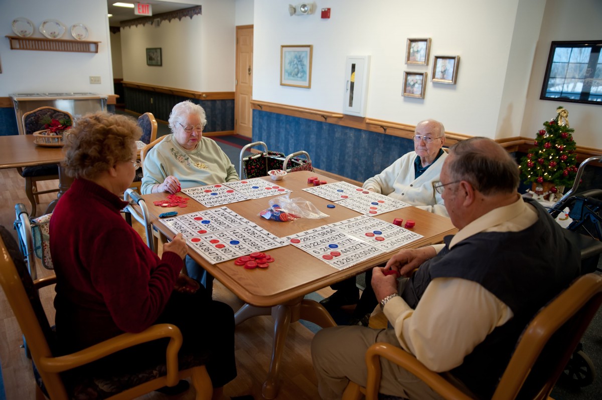 A group of seniors enjoying a game of bingo together in a community room.