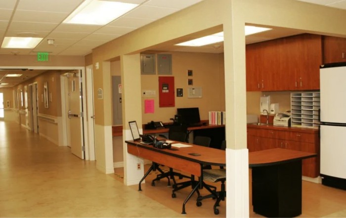 An office interior with desks and chairs arranged in a workspace.