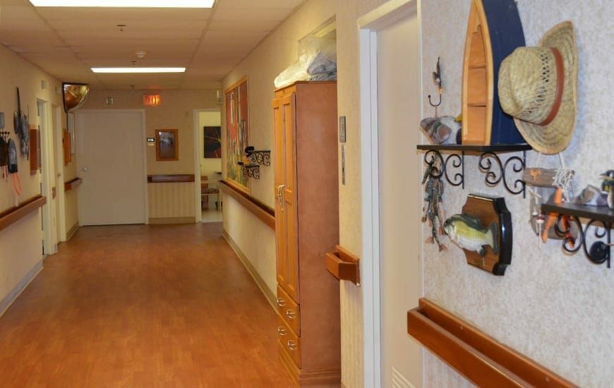 A quiet, well-lit hallway with wooden floors and decorative items on the wall.