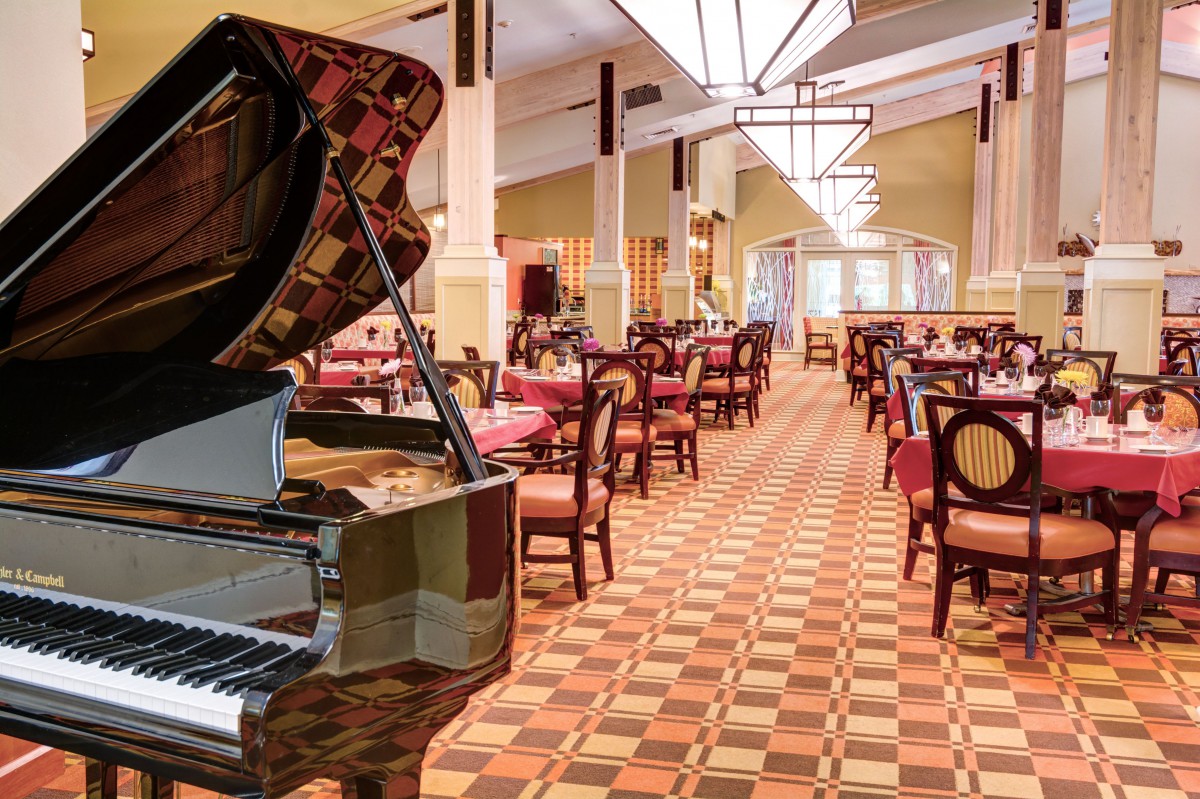 A spacious restaurant interior featuring a grand piano and elegant dining setup.