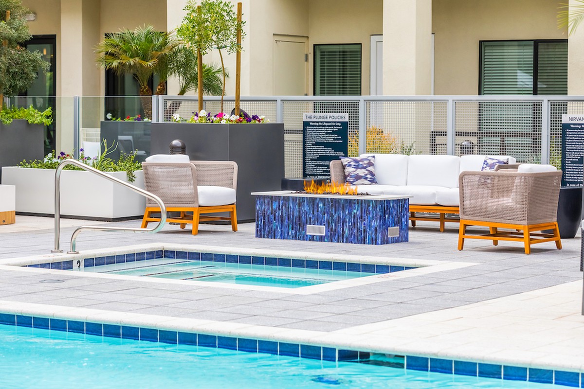 An inviting outdoor seating area by a pool with comfortable furniture and a modern design.