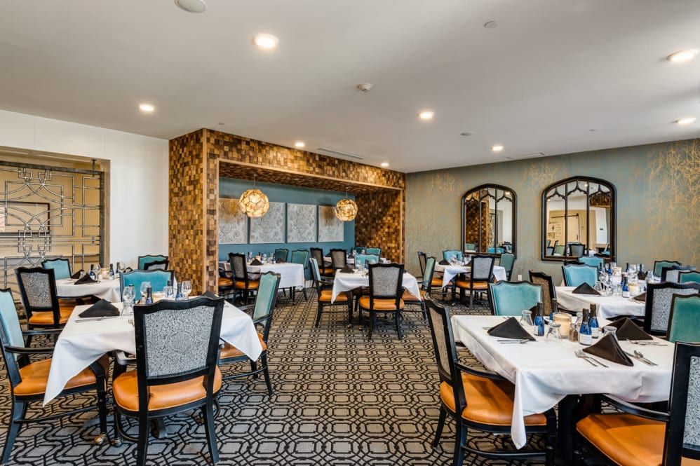 A stylishly decorated restaurant dining room with neatly arranged tables and chairs.