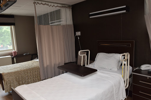 A clean and modern hospital patient room equipped with a bed and privacy curtains.