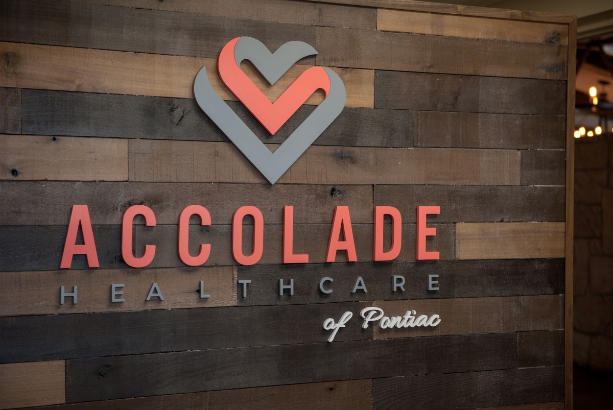 Accolade Healthcare logo on a wooden wall.