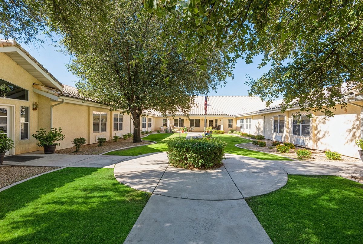 A serene courtyard with a circular walkway surrounded by buildings and lush greenery.