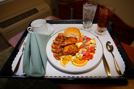 A delicious meal served on a tray, featuring chicken, salad, and beverages.