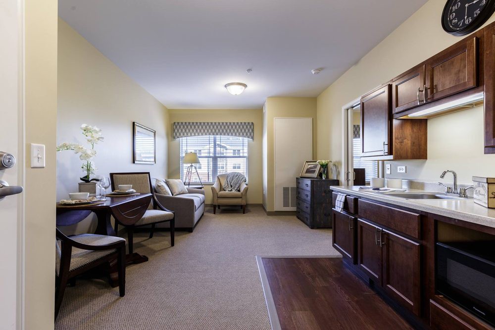 A cozy apartment interior featuring a living room with a kitchenette and dining area.