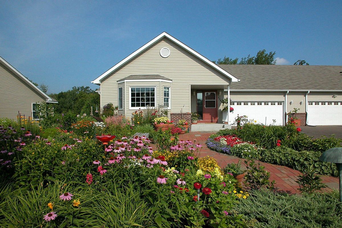 A charming house with a beautifully landscaped garden full of colorful flowers.