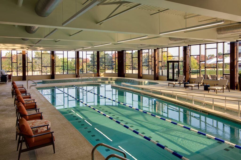 A spacious indoor swimming pool with lanes and natural lighting.