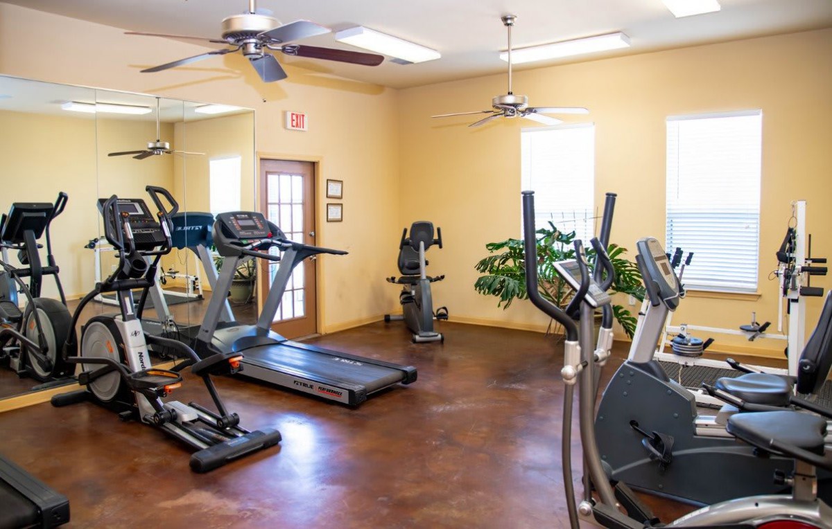 A well-equipped gym featuring treadmills, cardio machines, and a spacious workout area.