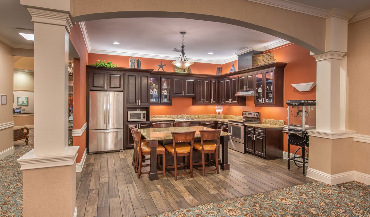A modern kitchen with wooden cabinets and stainless steel appliances, featuring an island counter.
