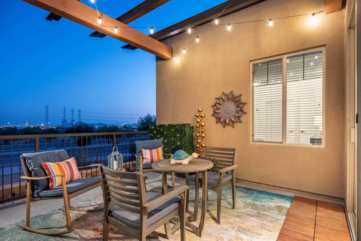 A cozy outdoor patio with seating, enhanced by warm string lights in the evening.