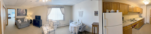 A cozy, minimalist dining area featuring a neatly set table and natural light filtering through the window.
