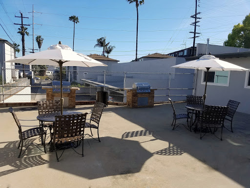 A sunny outdoor patio area featuring tables and umbrellas, perfect for enjoying the warm weather.