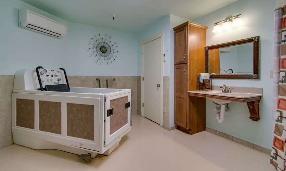 A well-lit bathroom featuring an accessible bathtub and a vanity with a sink.