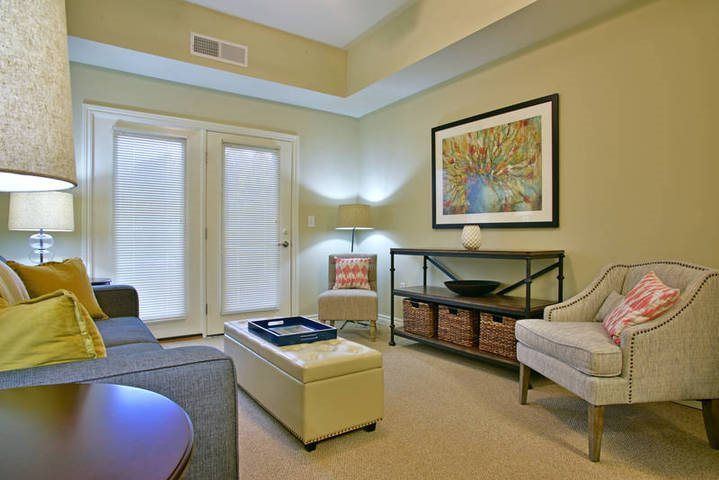 A modern and cozy living room featuring contemporary furniture, artwork, and warm lighting.