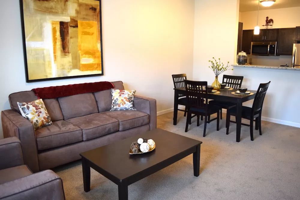 A cozy living and dining area with a sofa, coffee table, and modern decor.