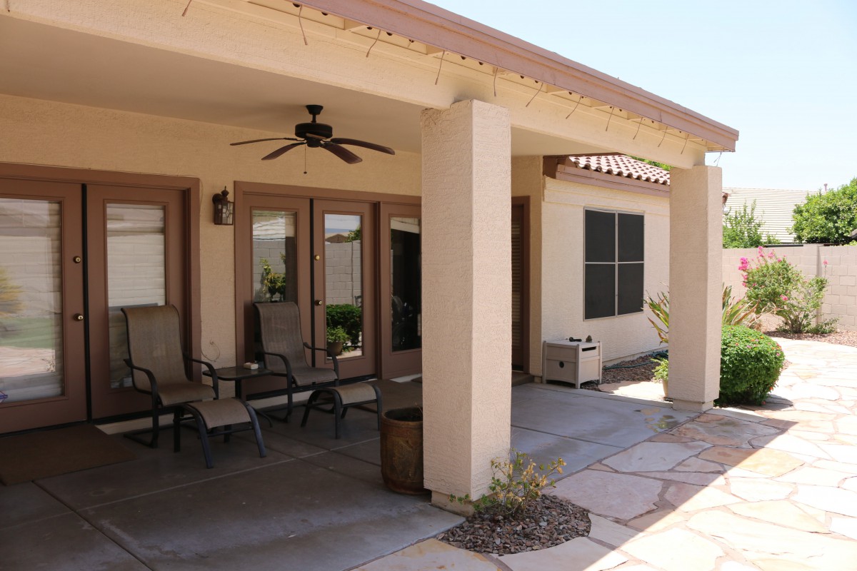 A cozy patio with outdoor seating and a ceiling fan for relaxation.