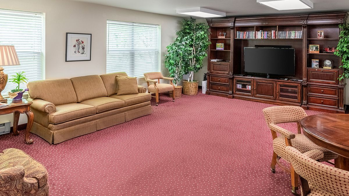 A cozy living room with a sofa, television, and bookshelf.