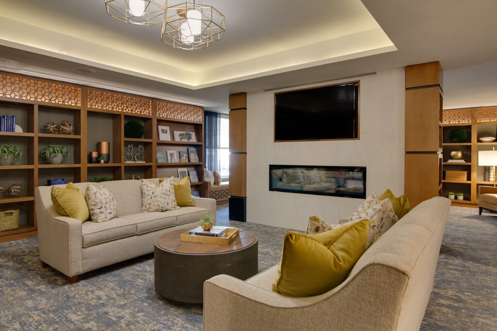 A modern living room with cozy seating, a fireplace, and elegant lighting.