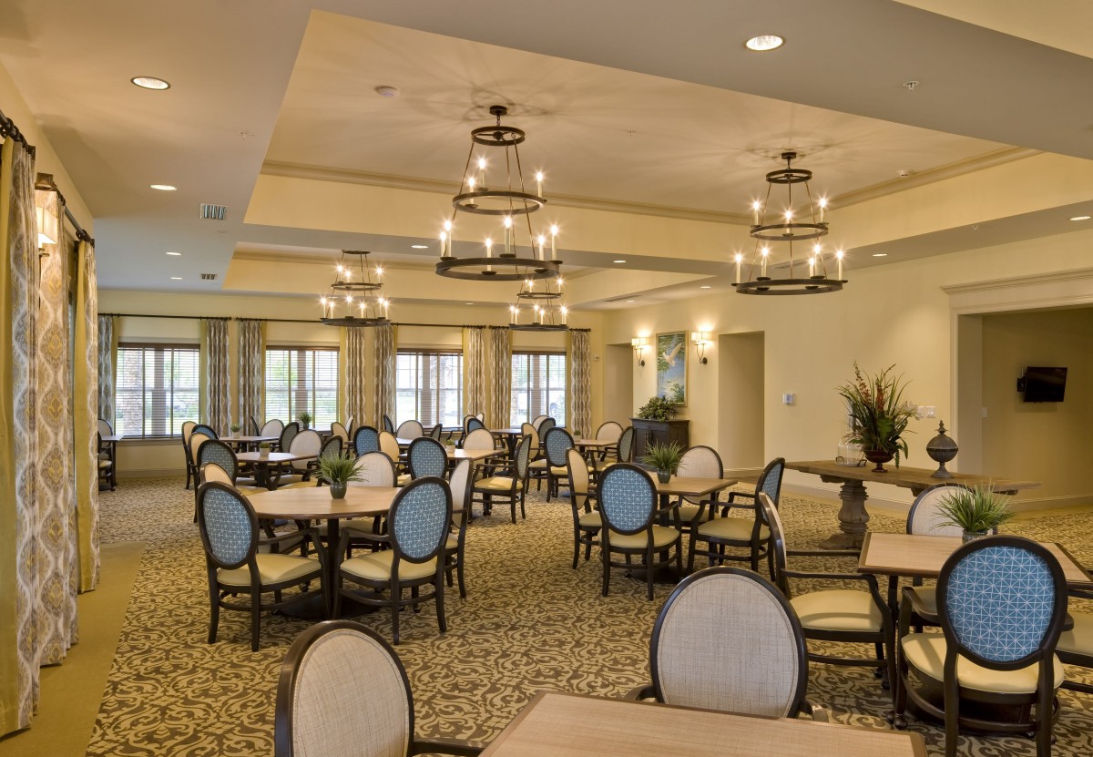 Elegantly designed dining room with round tables and chandelier lighting.