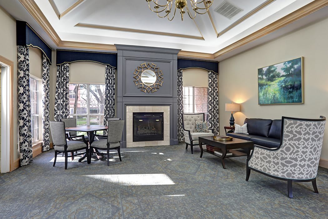 A cozy living room with elegant furnishings and a central fireplace.