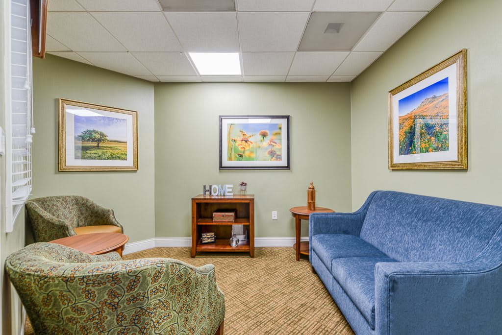 A cozy waiting room with comfortable seating and colorful artwork on the walls.