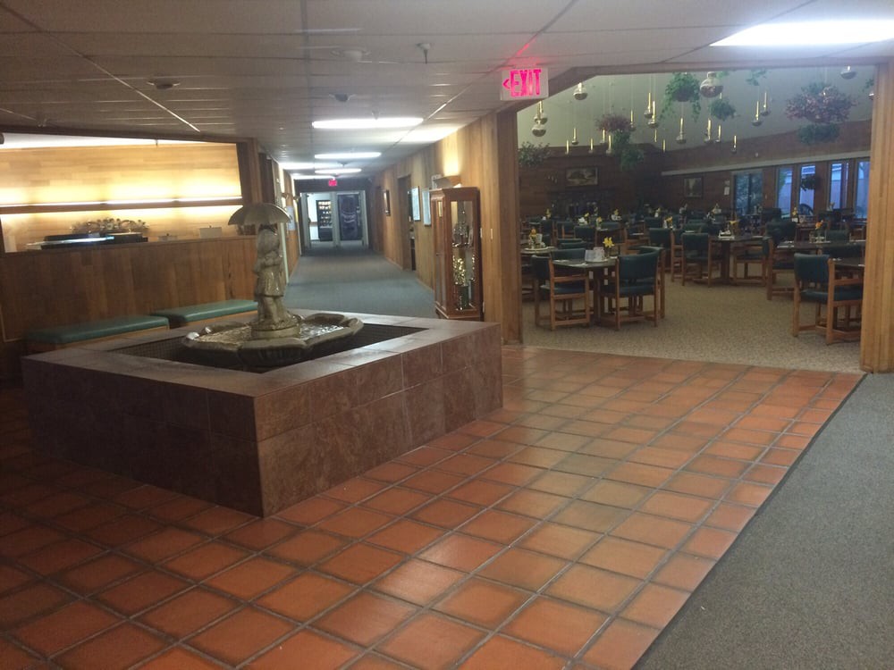 A hallway with a decorative fountain and visible restaurant seating area.