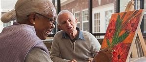 Two seniors engaged in a lively conversation by the window.