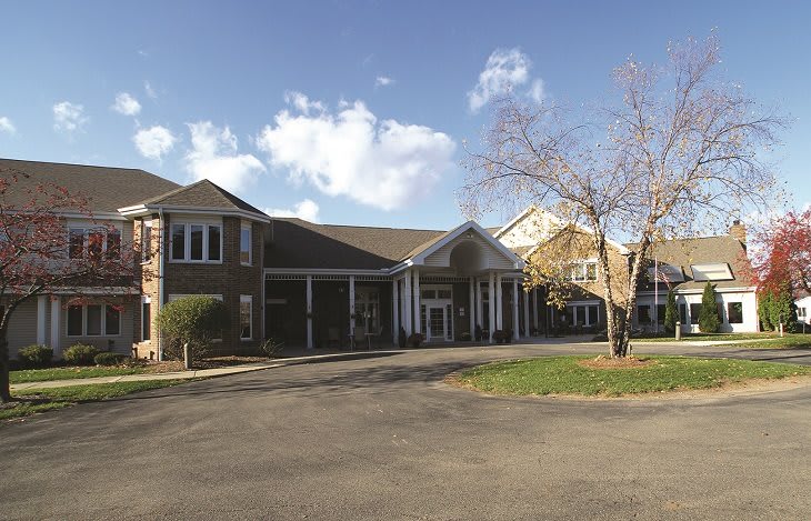 A large building with a prominent entrance under a partly cloudy sky.
