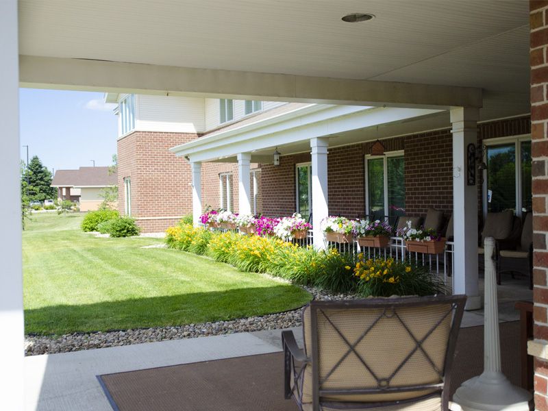 A well-maintained yard featuring a porch and colorful flower beds.