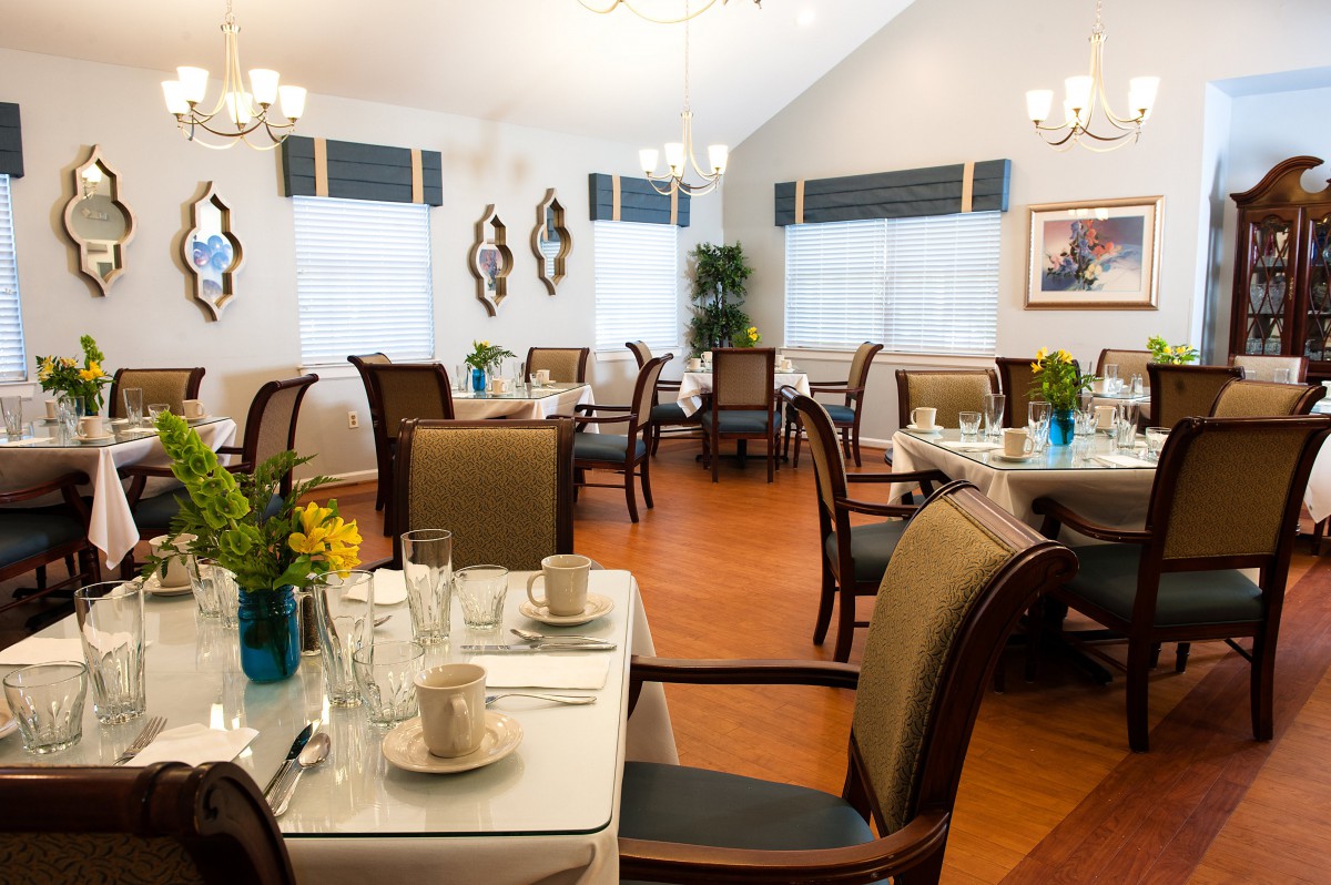 A well-lit dining room with neatly arranged tables and chairs, complemented by elegant decor.