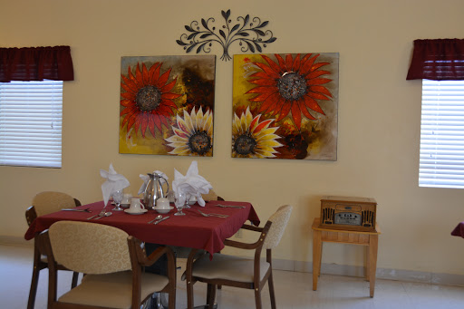 A cozy dining room featuring floral artwork and an inviting table setting.
