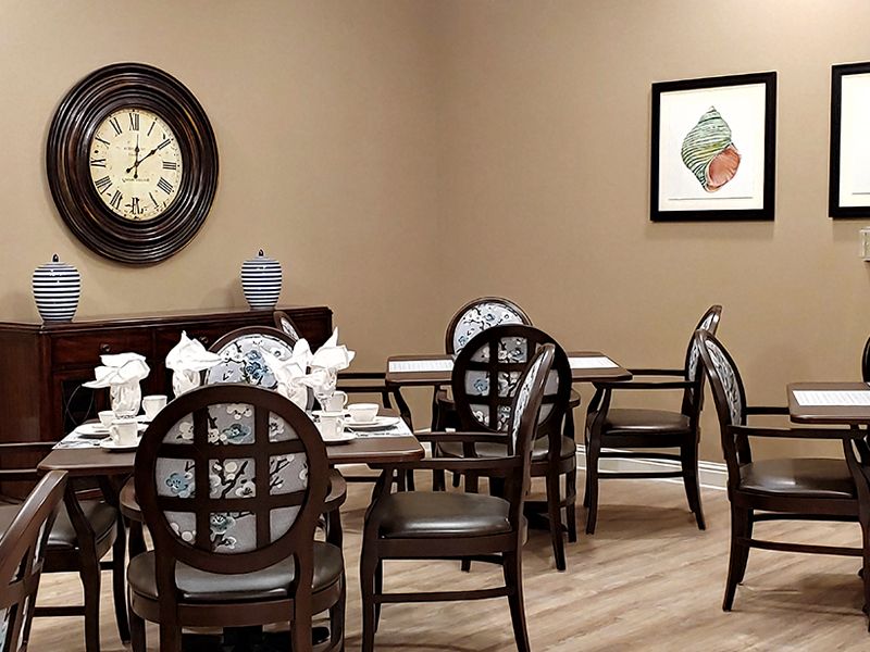 A cozy dining room with elegant table settings and wall decor.