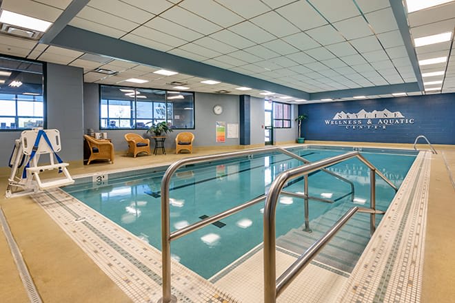 An inviting indoor swimming pool area with comfortable seating, perfect for relaxation and leisure activities.