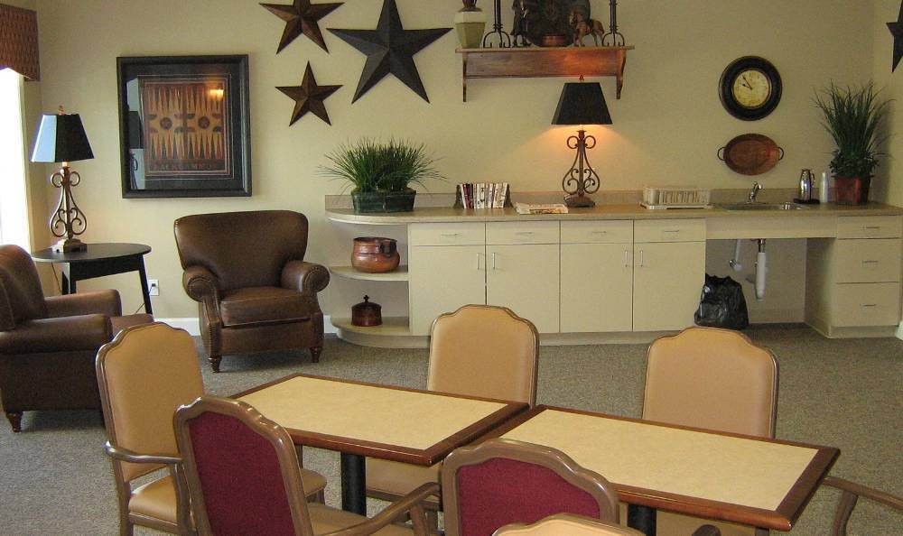 A cozy room with tables and chairs arranged for a casual setting, complemented by decorative elements like wall stars and a lamp.