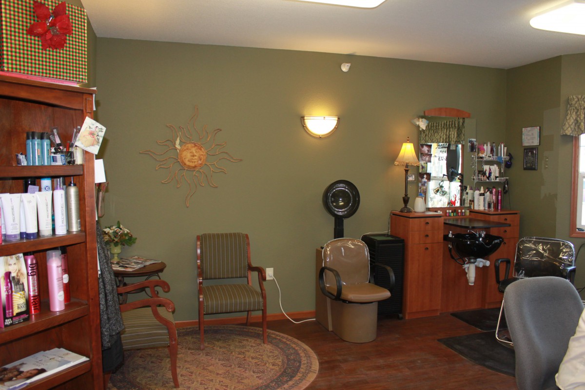 A cozy salon interior with seating and a hair styling station.