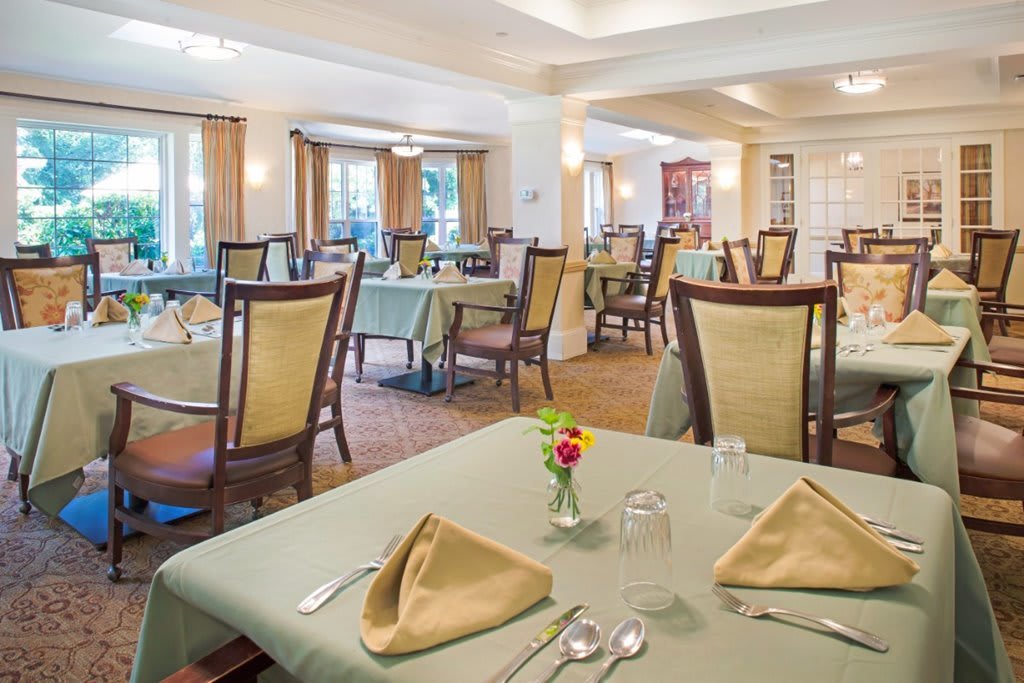 A spacious and elegantly arranged restaurant dining room with neatly set tables.