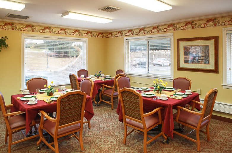 A cozy dining room with neatly arranged tables and chairs, featuring a warm interior design.