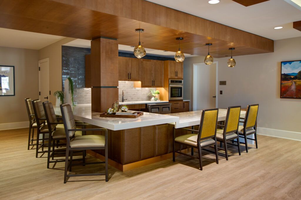 A modern kitchen with a central island, featuring wood accents and stylish pendant lighting.