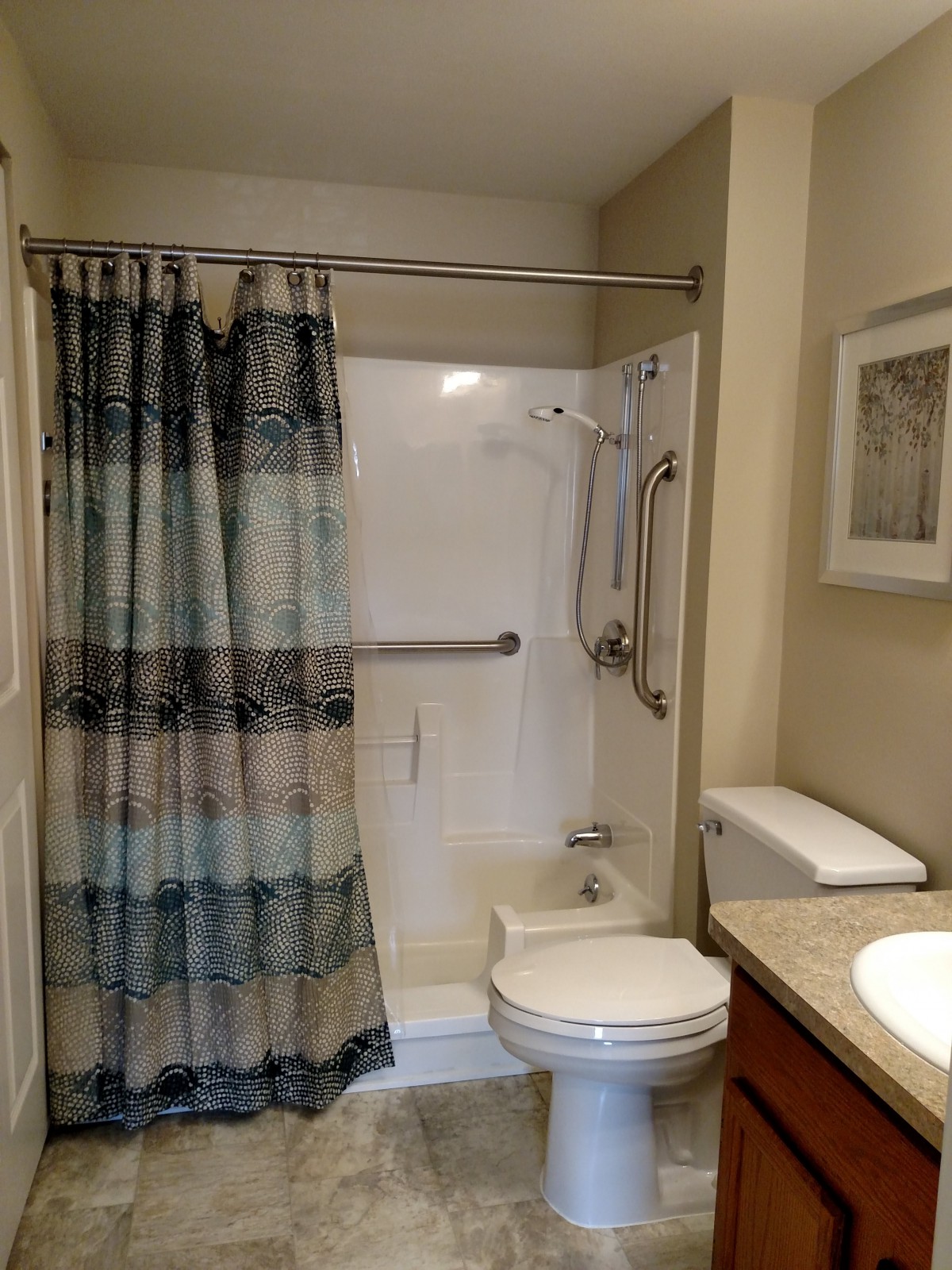 A clean and well-organized bathroom with a shower, toilet, and sink.