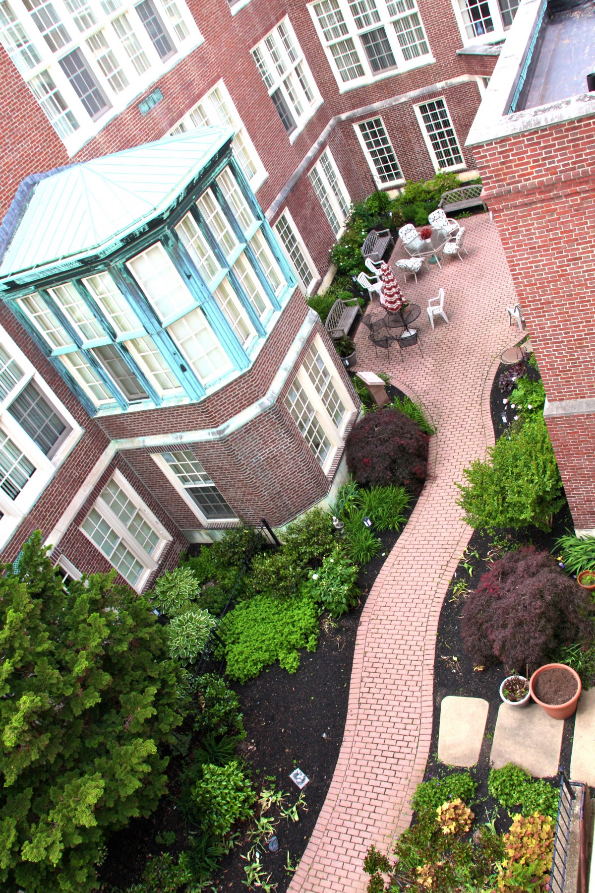 A well-maintained courtyard with brick pathways and garden landscaping.