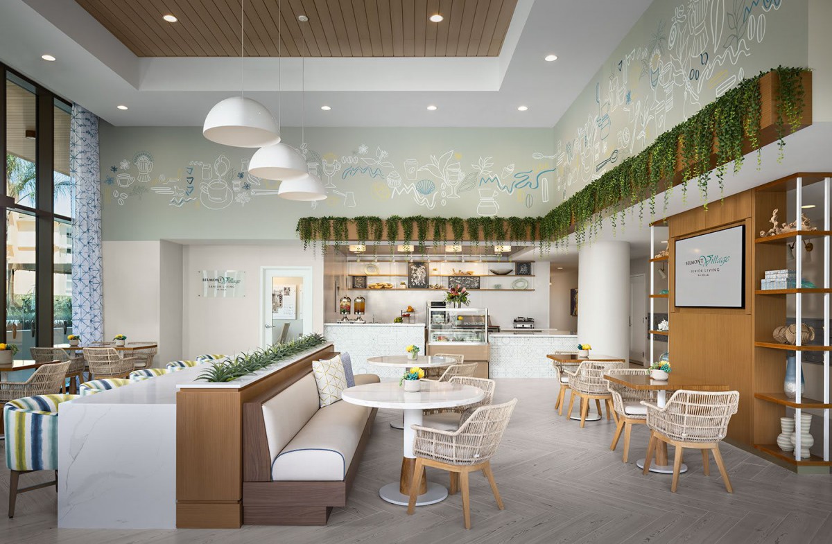 A modern cafe interior with cozy seating and greenery decor.