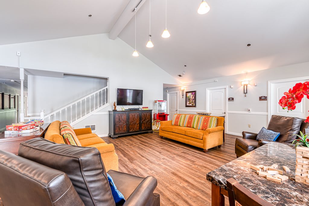 A spacious living room with modern furniture and wooden flooring.