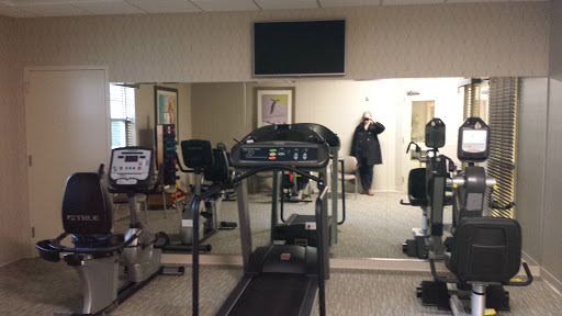 A glimpse of a gym featuring a treadmill and fitness equipment in an indoor setting.