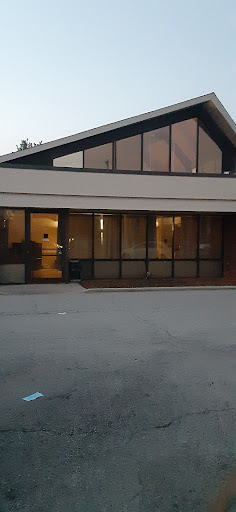 A modern building featuring a glass facade, captured during the evening hours.