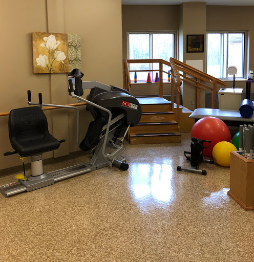A well-equipped rehabilitation center featuring various exercise equipment and colorful fitness balls.